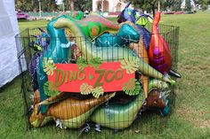 an inflatable dinosaur cage is full of balloons and decorations for the dino zoo