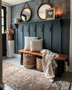 a bench with two mirrors above it and some baskets on the floor next to it