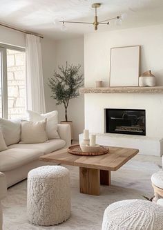 a living room filled with furniture and a fire place under a window next to a fireplace