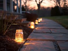 lighted mason jars lined up along a path