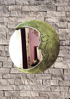 there is a mirror on the side of a brick wall that looks like a moon