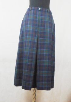 "A real classic vintage garment, beautifully made, elegant skirt by Daks London, plaid in dark blue, green and red. The two side pockets are lined in soft black leather, with full pleat front and back. full lining. This skirt even has small belt loops so you can wear a skinny tan leather belt. This is your perfect Autumn / Winter skirt. Marked: 100% pure new wool, Daks London, size 12 to fit hips 96 cm, made in Great Britain. Condition: in perfectly condition, looks new. Dimensions: Waist: 36cm Tan Leather Belt, Silk Chiffon Scarves, Small Belt, Winter Skirt, Elegant Skirt, Chiffon Scarf, Wool Skirt, Mid Length Skirts, Tank Top Camisole