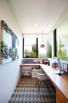 an office with a desk, chair and painting on the wall