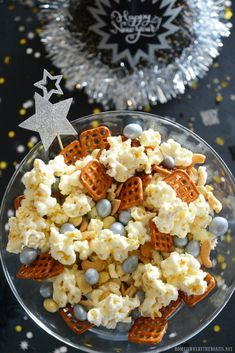 a bowl filled with popcorn and blue candies on top of a table next to a silver star