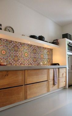 a kitchen with wooden cabinets and a clock on the wall above it's counter