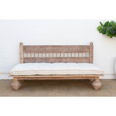 a wooden bench sitting on top of a tile floor next to a potted plant