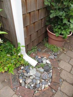 there is a shovel in the middle of some rocks and gravel next to a fence