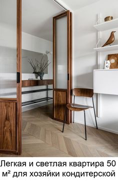 an open door in a room with wooden flooring and white walls, next to a chair