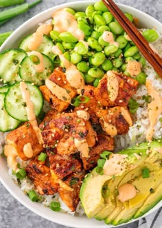 a bowl filled with rice, meat and veggies next to chopsticks