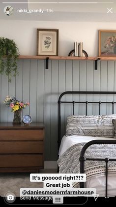 a bed room with a neatly made bed and some pictures on the wall above it