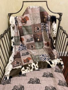 a baby crib with a cow print blanket on it's side and a toy car in the background