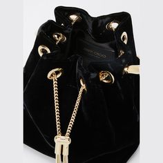 Jimmy Choo "Bon Bon" top-handle bag in velvet. Round metal top handle; box-chain crossbody strap. Metal chain drawstring closure. Textile lining. 5.9"H x 5.5"W x 3.7"D. Made in Italy. Luxury Top Handle Bucket Bag For Gift, Elegant Party Bucket Bag With Gold-tone Hardware, Luxury Party Bucket Bag With Gold-tone Hardware, Luxury Bucket Style Formal Evening Bag, Gold-tone Bucket Evening Bag, Luxury Bucket Style Evening Bag For Formal Occasions, Luxury Bucket Evening Bag For Formal Occasions, Gold-tone Hardware Evening Bucket Bag, Luxury Party Bucket Bag With Chain Strap