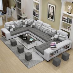 a modern living room with grey and white couches, coffee table and ottomans