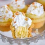 small cupcakes with white frosting and sprinkles on a glass plate