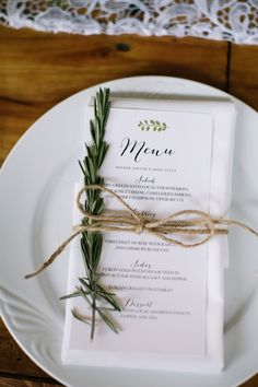 a white plate topped with a menu on top of a wooden table