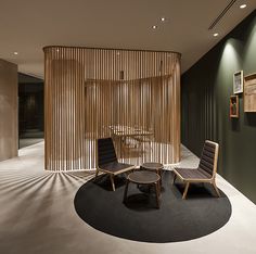 two chairs and a table in front of a wall with wooden slats on it