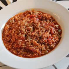 a white bowl filled with lots of food on top of a black and white table cloth