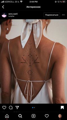 the back of a woman's dress with tattoos on her upper and lower back