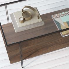 a coffee table with a book on it and a vase sitting on top of it