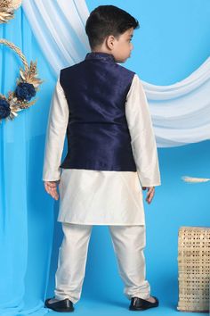 Navy blue embroidered nehru jacket in silk blend fabric, has mandarin collar, straight hemline, full front button placket with embroidered buttons. Cream color straight solid knee length kurta, has a mandarin collar, long sleeves, straight hem, button with button placket, side slits. Comes with cream solid pyjama, has elasticated waistband, slip-on closure.Vastramay present silk blend navy blue embroidered strappy square neck crop top with frill detailing. Comes with draped viscose skirt, has el Festive Nehru Jacket For Eid With Stand Collar, Festive Nehru Jacket With Stand Collar For Eid, Eid Festive Nehru Jacket With Stand Collar, Fitted Nehru Jacket With Embroidered Border For Festivals, Blue Nehru Jacket With Stand Collar For Winter, Blue Winter Nehru Jacket With Stand Collar, Blue Long Sleeve Bandhgala For Spring, Blue Nehru Jacket With Stand Collar For Festive Occasions, Festive Blue Nehru Jacket With Long Sleeves