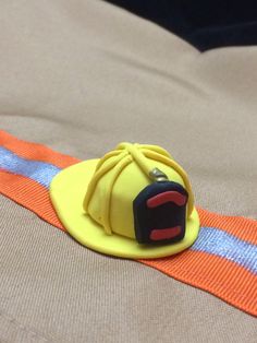 a yellow fireman's hat sitting on top of an orange safety belt