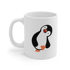 a white coffee mug with a cartoon penguin on it's side and an orange beak