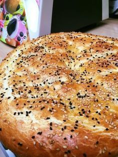 a large round bread with sesame seeds on it