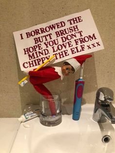 an elf with a toothbrush and sign on the sink