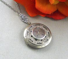 This enchanted locket is 28 inches long. Antique finished round silver locket has beautiful engraved floral patterns on the sides. I have set a antique silver finished Victorian inspired ornament which is embellish with pewter Labyrinth Celtic embellishment. Pendant is finished with silver floral connector, antique silver metal chain, and lobster clasp.. Locket is 32mm in size. It has room for two photos inside! Please note: I DO NOT DO ENGRAVING OR INSERT PICTURES! Thanks for looking:) Mani Bohemian Engraved Round Locket Necklace, Engraved Spiritual Locket Necklace Adjustable, Adjustable Engraved Spiritual Locket Necklace, Bohemian Silver Locket Necklace, Silver Spiritual Locket Necklace, Bohemian Silver Locket Necklace With Round Pendant, Silver Bohemian Engraved Locket Necklace, Nickel-free Silver Bohemian Locket Necklace, Spiritual Nickel-free Locket Necklace