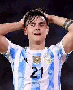 a young man holding his head with both hands and wearing a blue and white shirt