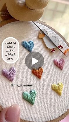 someone is stitching hearts on a small piece of fabric with the words, sima hoesinii written in arabic