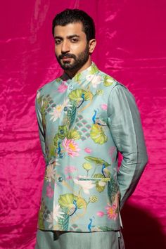 Mint nehru jacket with floral print. Comes with white pant and a kurta.
Components: 3
Pattern: Printed
Type Of Work: Floral
Neckline: Chinese collar
Sleeve Type: Nehru Jacket: Sleeveless, Kurta: Full
Fabric: Chanderi silk, Cotton satin
Color: Blue,Green
Other Details: 
Length:
Kurta: 46 inches
Pant: 40 inches
Closure: Nehru Jacket and Kurta - Front buttons
Occasion: Sangeet - Aza Fashions Sleeveless Kurta, White Pant, Kurta Set For Men, Chinese Collar, Nehru Jacket, Types Of Work, Nehru Jackets, Satin Color, Kurta Set