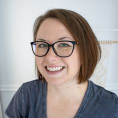 a woman with glasses smiling for the camera