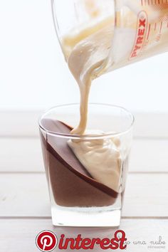 someone pouring milk into a glass filled with ice cream