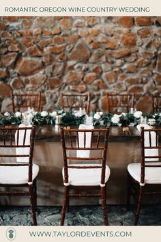 the table is set with white chairs and greenery on it for a rustic wedding