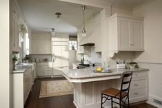 a large kitchen with white cabinets and an island in the middle of the room is shown