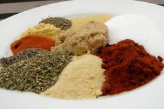 several different types of spices on a white plate