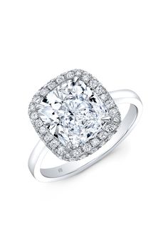 a cushion cut diamond ring with diamonds on the shoulders and sides, set in 18k white gold