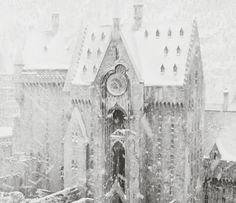 a black and white photo of an old building with snow falling on it's roof