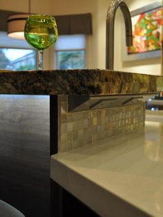 a wine glass sitting on top of a counter next to a sink in a kitchen