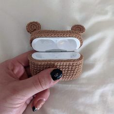 a person is holding an electronic device with a bear design on it's case