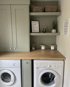 a washer and dryer in a small room next to each other with shelves above them