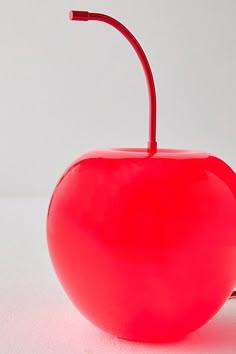 a red apple shaped object sitting on top of a table