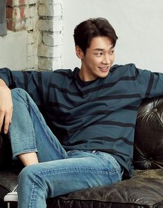 a young man sitting on top of a black couch