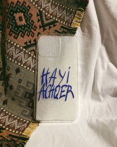 a phone case with the word haii archer written in blue ink on white fabric