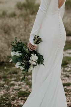 a woman in a wedding dress holding a bouquet