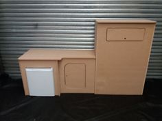 a cardboard box sitting on top of a black floor next to a metal garage door