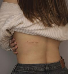 a woman's stomach with the word love tattooed on her lower side ribcage