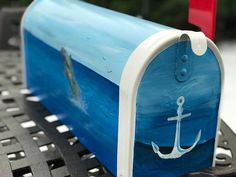 a blue and white mailbox with an anchor painted on it