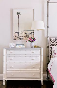 a bedroom with white furniture and pink accents